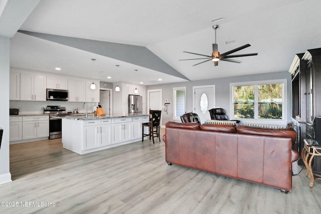living area with ceiling fan, recessed lighting, visible vents, vaulted ceiling, and light wood-type flooring