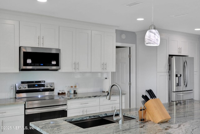 kitchen featuring white cabinetry, visible vents, stainless steel appliances, and a sink