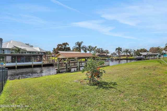 view of dock with a water view and a lawn