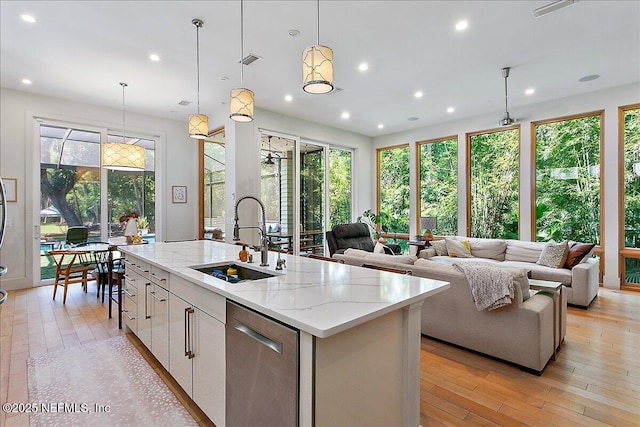 2446 Seminole Rd, Atlantic Beach, FL 32233 - kitchen featuring a sink, open floor plan, stainless steel dishwasher, light wood-type flooring, and an island with sink