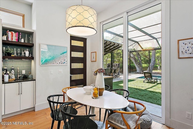 2446 Seminole Rd, Atlantic Beach, FL 32233 - dining area with baseboards, a sunroom, and light wood-style floors