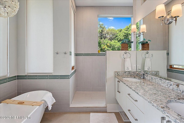 2446 Seminole Rd, Atlantic Beach, FL 32233 - bathroom featuring double vanity, a sink, walk in shower, a freestanding bath, and tile walls