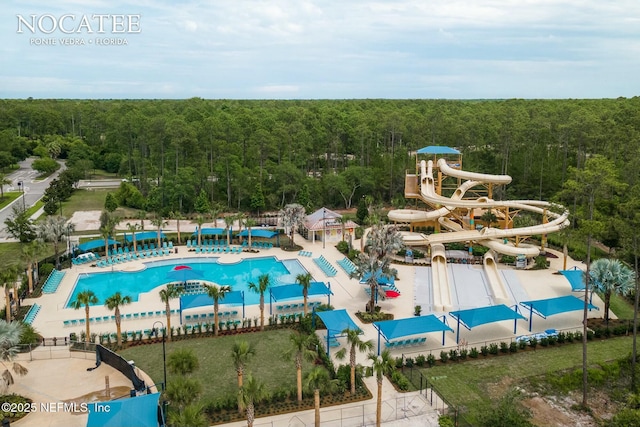 view of swimming pool featuring a view of trees