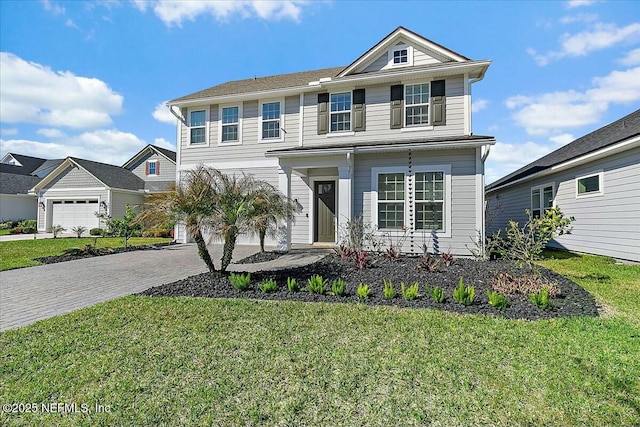 view of front facade featuring a front yard, decorative driveway, and a garage