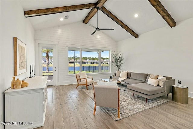 living room featuring ceiling fan, beamed ceiling, light wood-style floors, and high vaulted ceiling