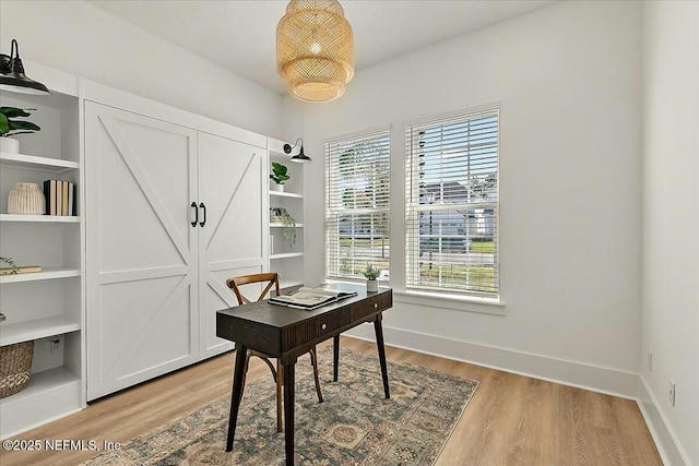 home office featuring baseboards and light wood finished floors