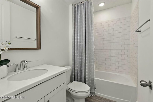 bathroom with toilet, wood finished floors, vanity, and shower / bath combination with curtain