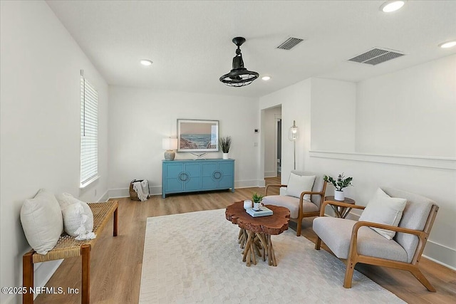 living area with recessed lighting, wood finished floors, and visible vents