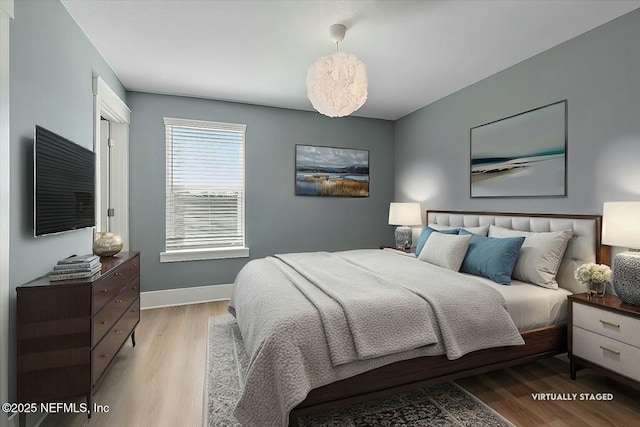 bedroom with light wood-style flooring and baseboards