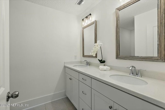 full bathroom featuring a textured ceiling, visible vents, tile patterned flooring, and a sink