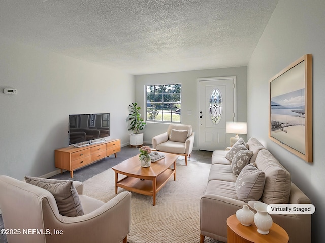 living area with light carpet, a textured ceiling, and baseboards