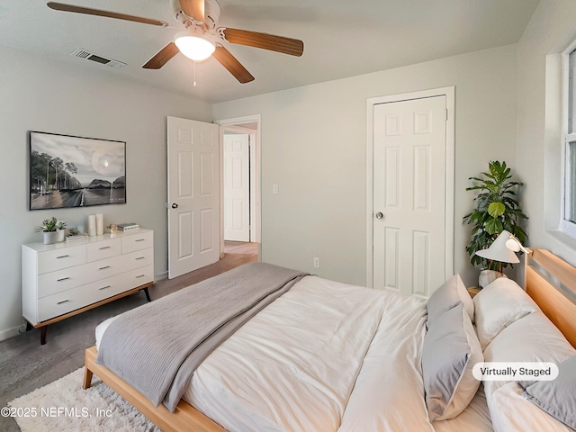 bedroom featuring a ceiling fan, dark colored carpet, and visible vents