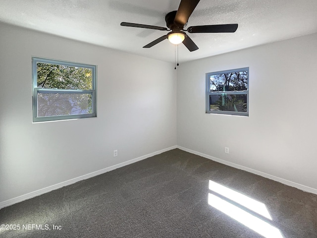 unfurnished room featuring a textured ceiling, carpet, a ceiling fan, and baseboards