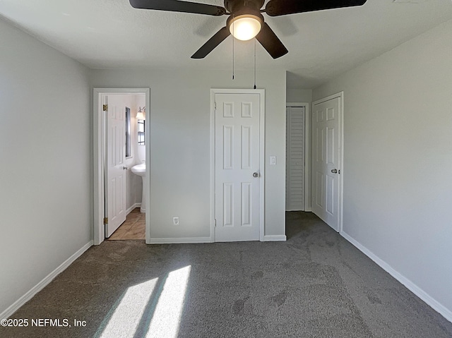 unfurnished bedroom featuring ensuite bathroom, carpet, a ceiling fan, and baseboards