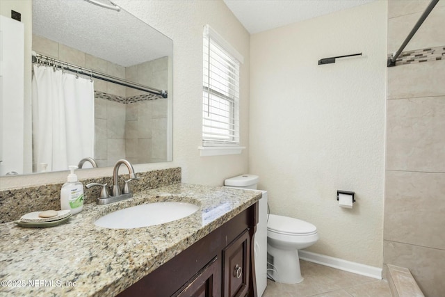 bathroom with toilet, a textured ceiling, vanity, tiled shower, and baseboards