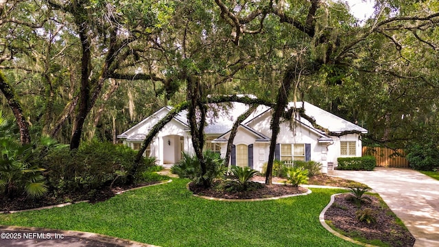 view of front of home with a front yard, fence, and driveway