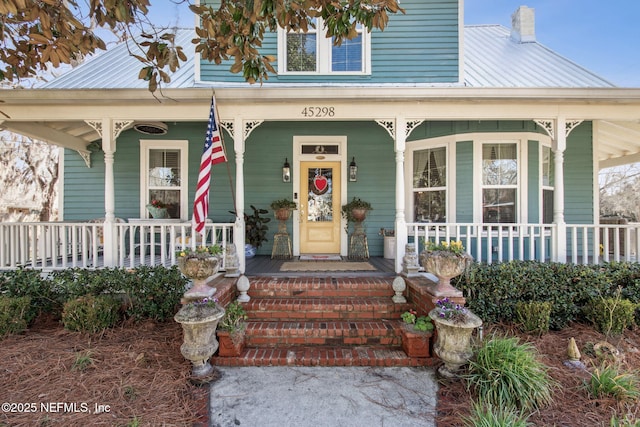 property entrance featuring metal roof and a chimney