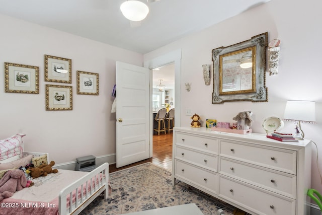 bedroom with wood finished floors and baseboards