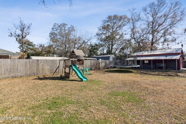 view of yard with a trampoline, a playground, and a fenced backyard