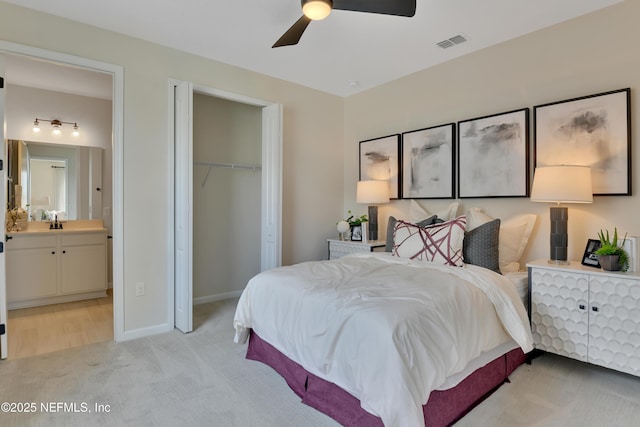 bedroom featuring a closet, baseboards, visible vents, light colored carpet, and a sink