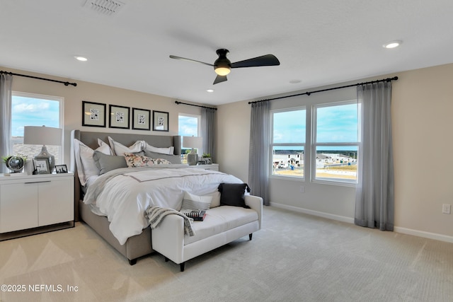 bedroom with light carpet, baseboards, multiple windows, and visible vents