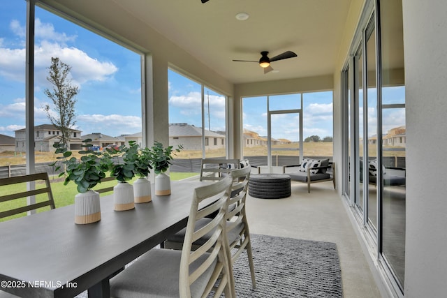 sunroom / solarium with ceiling fan and a residential view