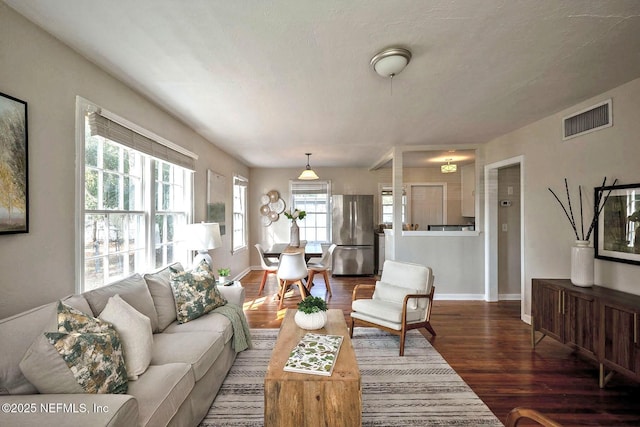 living area featuring wood finished floors, visible vents, and baseboards