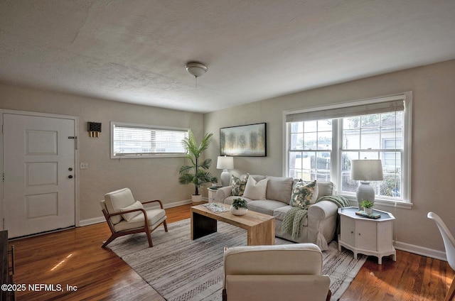 living area with plenty of natural light, wood finished floors, and baseboards