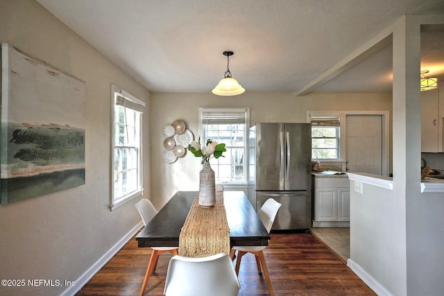 dining space featuring baseboards and dark wood-style flooring