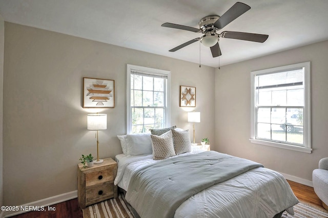 bedroom with ceiling fan, baseboards, and wood finished floors