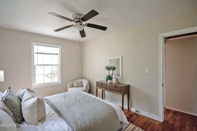 bedroom featuring baseboards, wood finished floors, and a ceiling fan