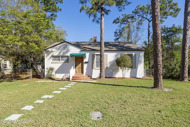 view of front of house with entry steps, a front lawn, and fence