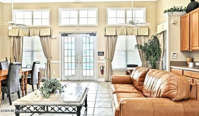 living area with a ceiling fan, a wealth of natural light, french doors, and a high ceiling