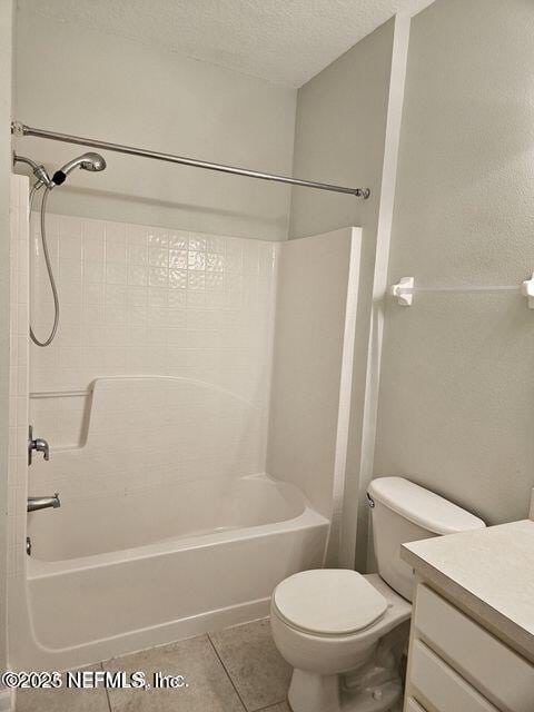 bathroom with a textured ceiling, tile patterned flooring, toilet, vanity, and bathing tub / shower combination