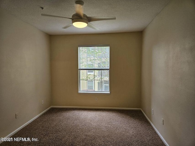 spare room with a textured ceiling, carpet floors, a ceiling fan, and baseboards