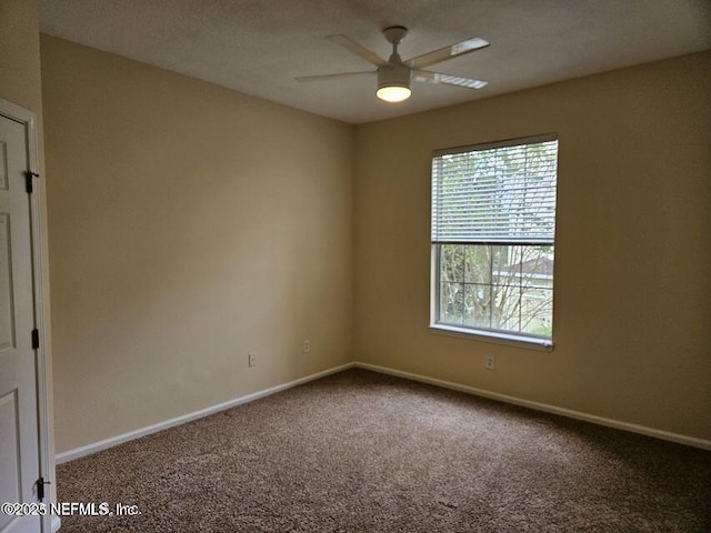 unfurnished room featuring carpet and baseboards