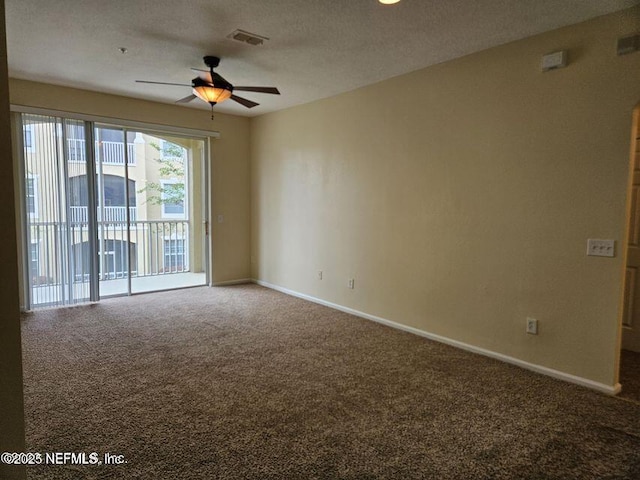 empty room with a textured ceiling, carpet flooring, a ceiling fan, and baseboards