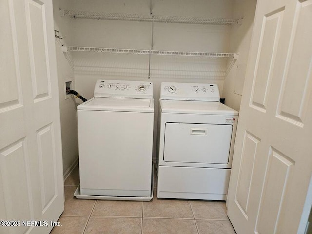 washroom featuring laundry area, light tile patterned floors, and separate washer and dryer