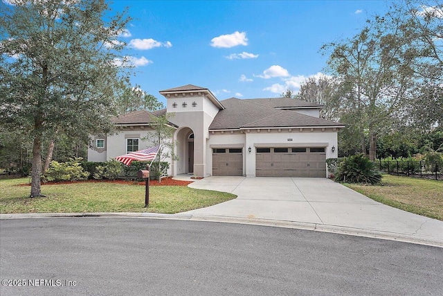 mediterranean / spanish house featuring roof with shingles, stucco siding, concrete driveway, an attached garage, and a front yard