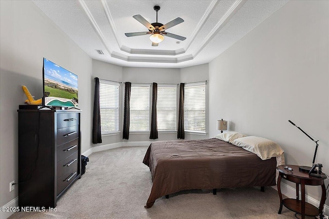 bedroom featuring baseboards, ornamental molding, a raised ceiling, and light colored carpet