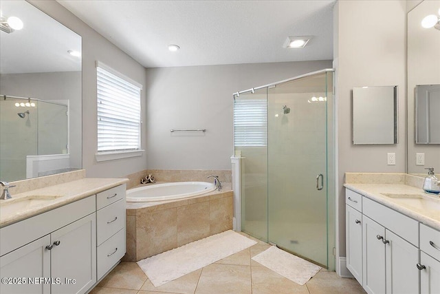 full bath with a stall shower, tile patterned flooring, a garden tub, and a sink