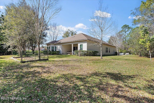 view of side of home with a yard and stucco siding