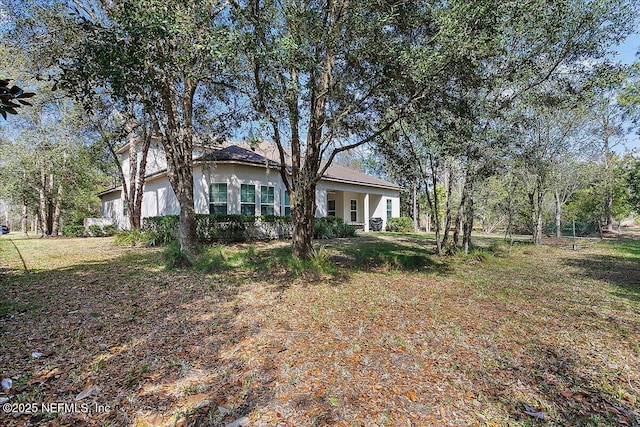 view of front of home with an attached garage, a front lawn, and stucco siding