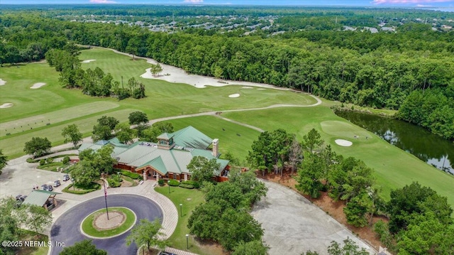 drone / aerial view featuring view of golf course, a water view, and a view of trees