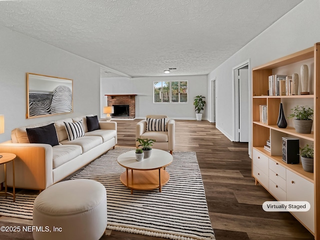 living area with a textured ceiling, baseboards, a fireplace, and dark wood-style flooring