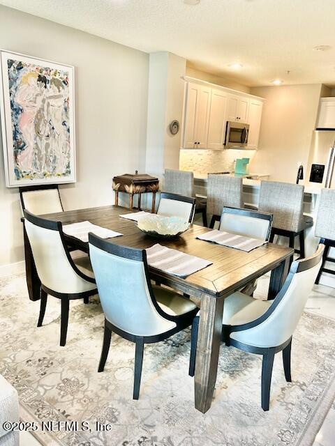 dining area with a textured ceiling and baseboards