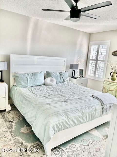 bedroom featuring a textured ceiling and a ceiling fan