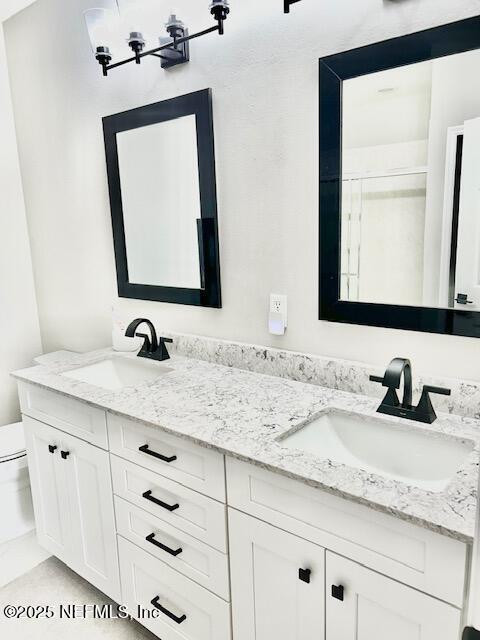 full bath featuring a sink, toilet, and double vanity