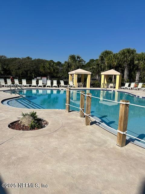 pool with a patio area and a gazebo