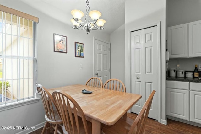 dining space with a chandelier, dark wood finished floors, and a wealth of natural light